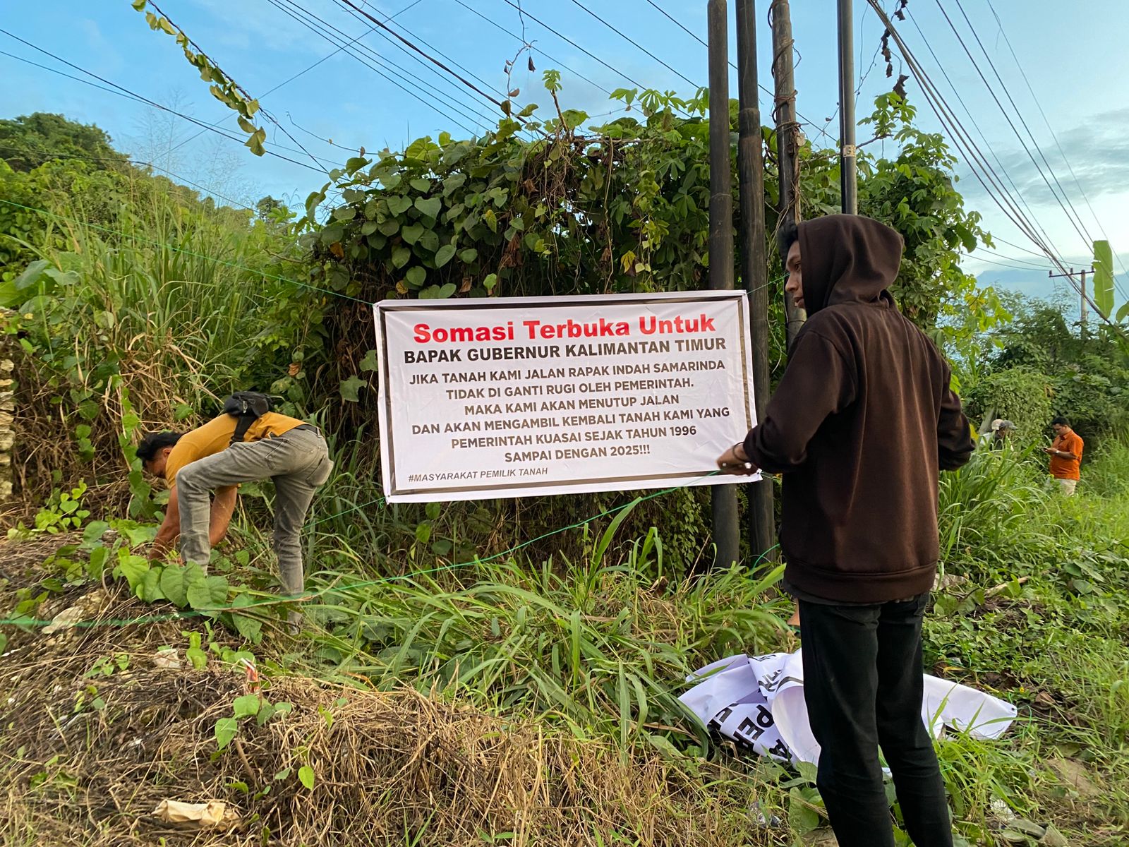 BEBERAPA Warga memasang spanduk protes di tepi Jalan Rapak Indah, Rabu (29/10/2025).